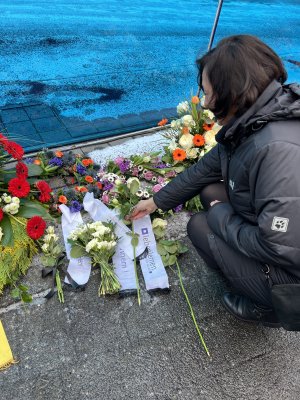 Eine Frau legt eine wei&szlig;e Rose neider