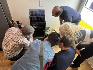 Mehrere Menschen gucken in einen 3D Drucker